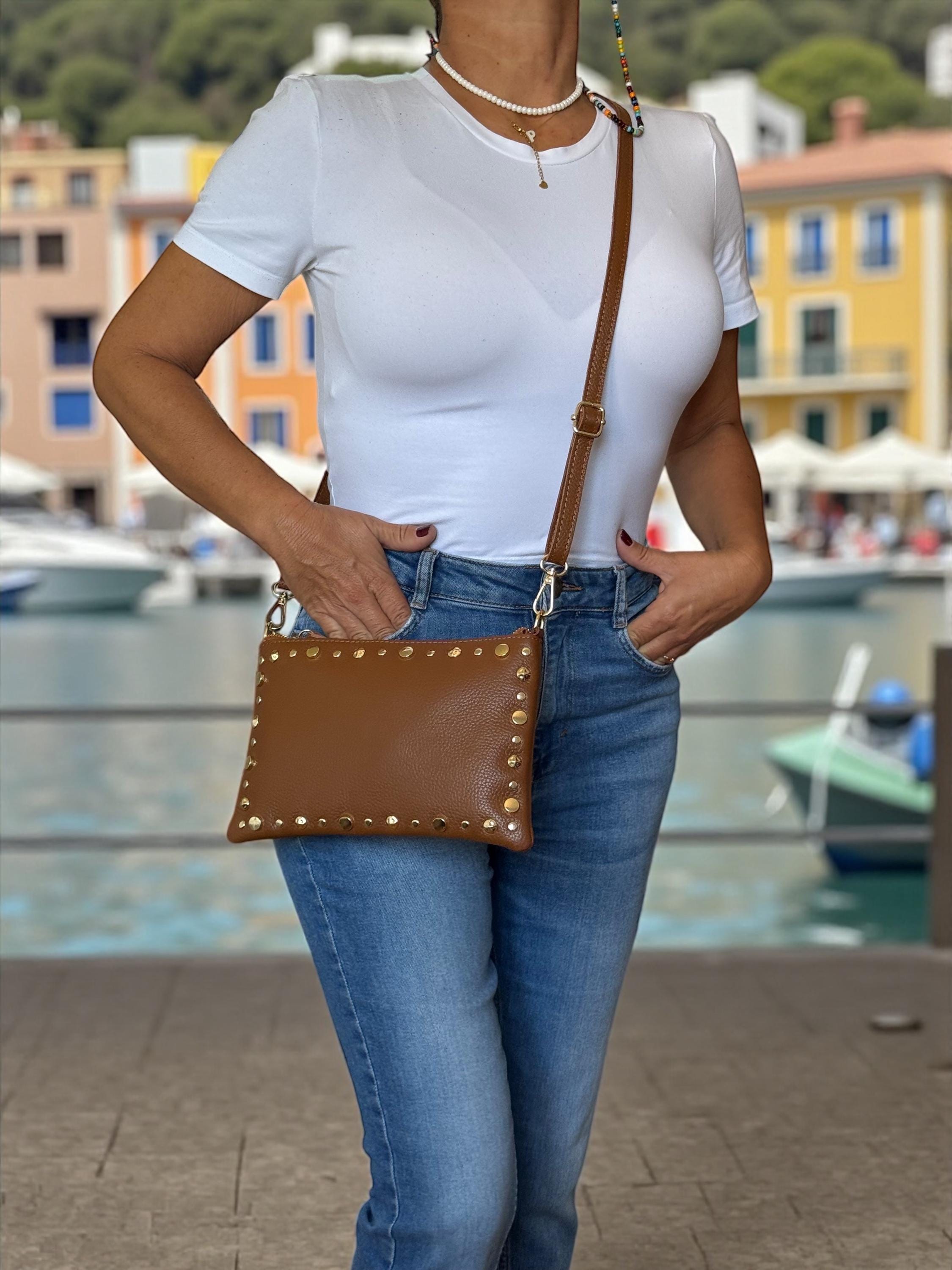 Clutch de piel granulada marrón camel con ribete dorado y tachuelas