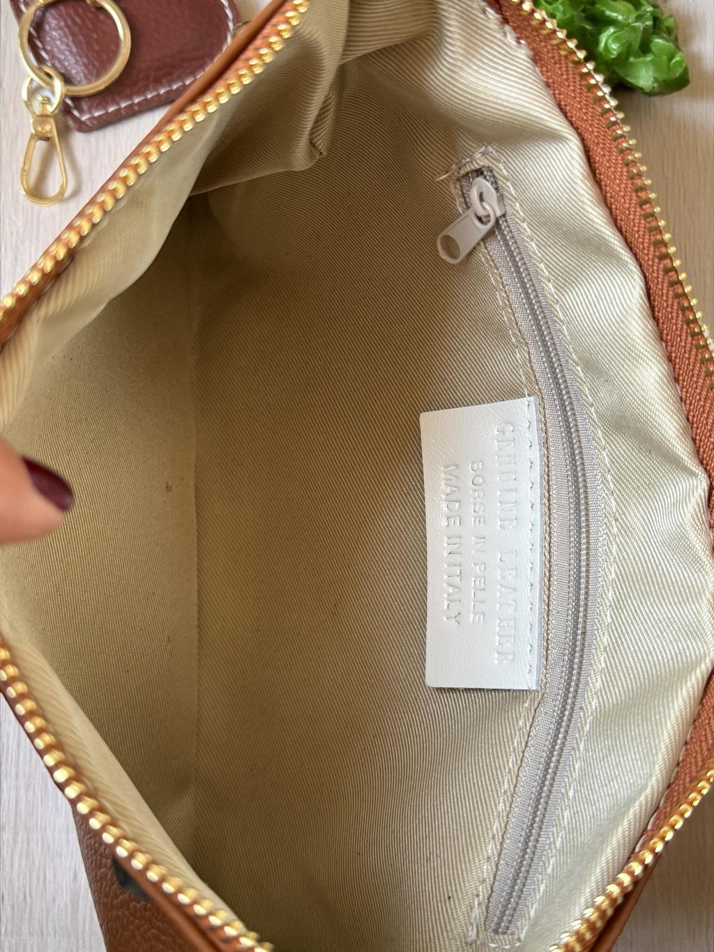 Clutch de piel granulada marrón oscuro con ribete dorado y tachuelas -