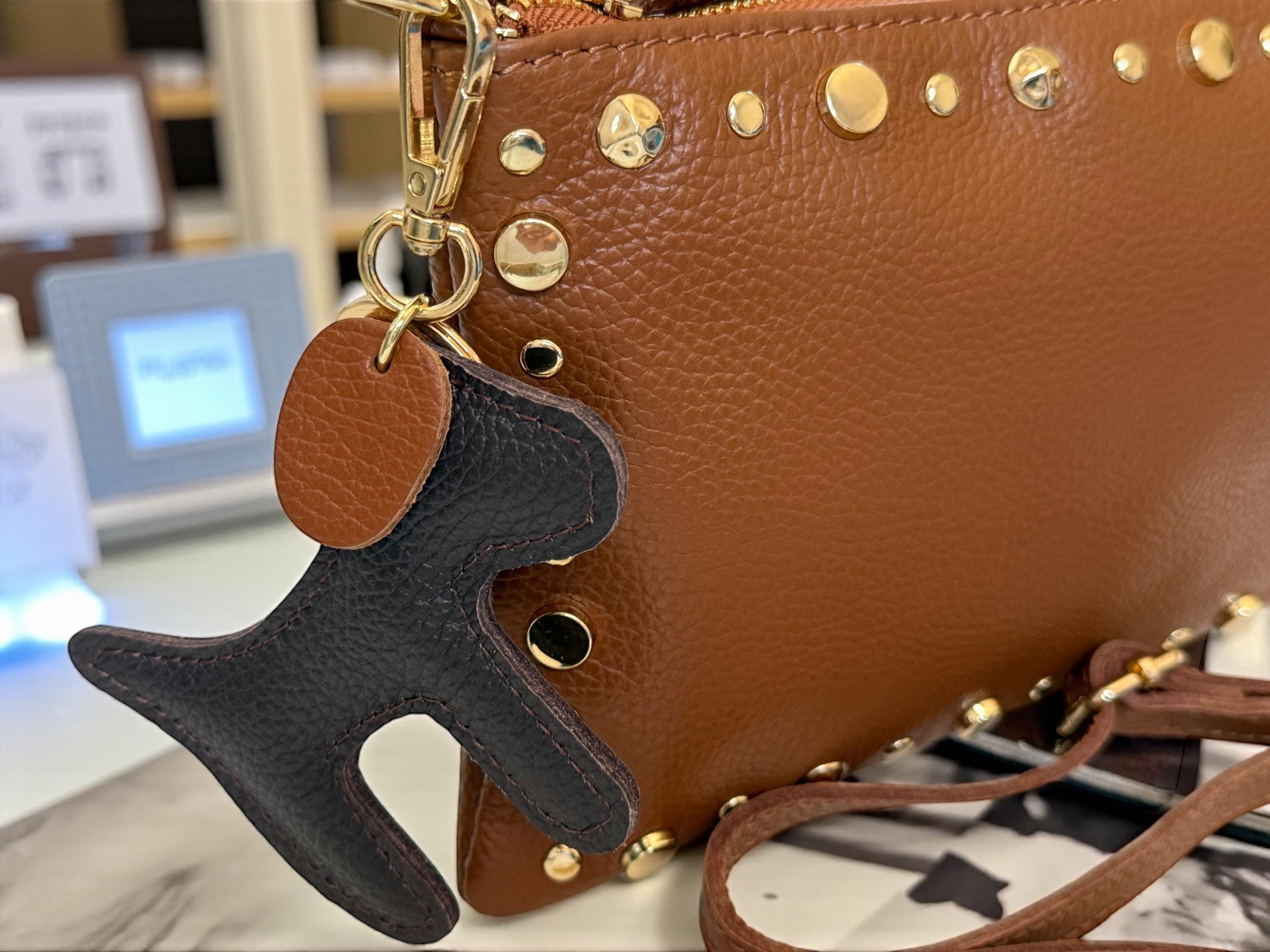 Clutch de piel granulada marrón oscuro con ribete dorado y tachuelas -