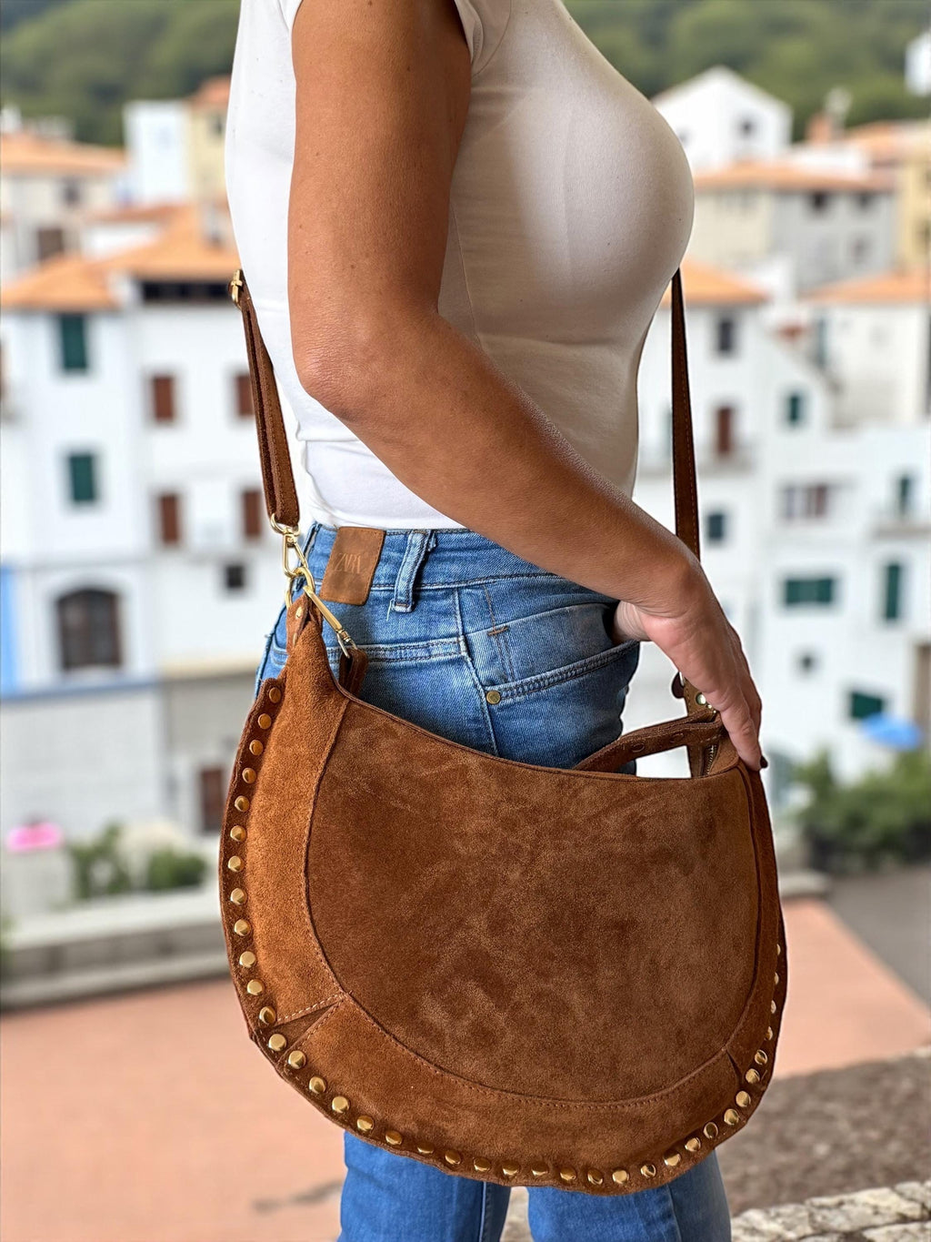 Bolso de hombro en forma de media luna de ante color camello con tachuelas doradas