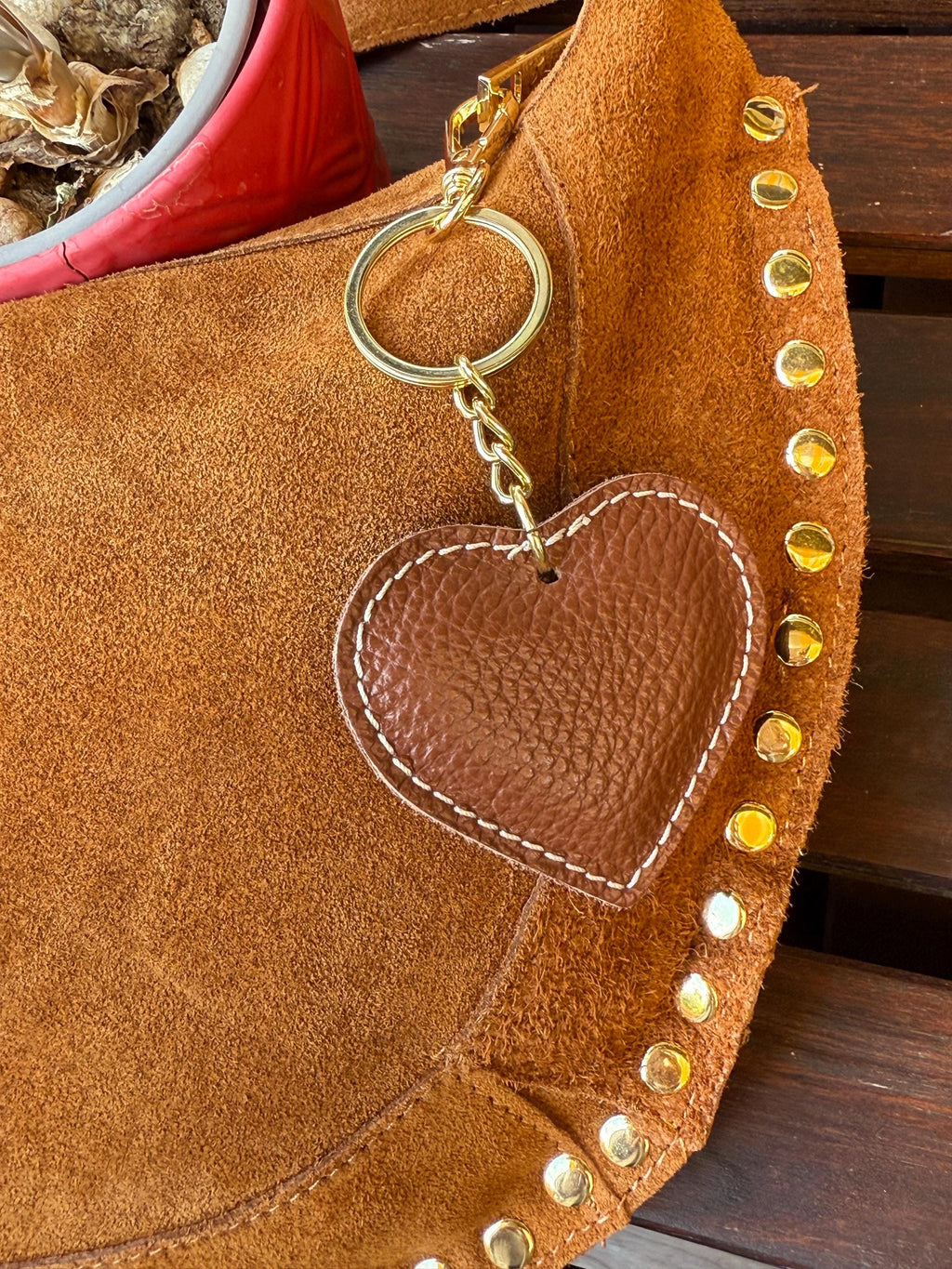 Bolso de hombro en forma de media luna de ante color camello con tachuelas doradas