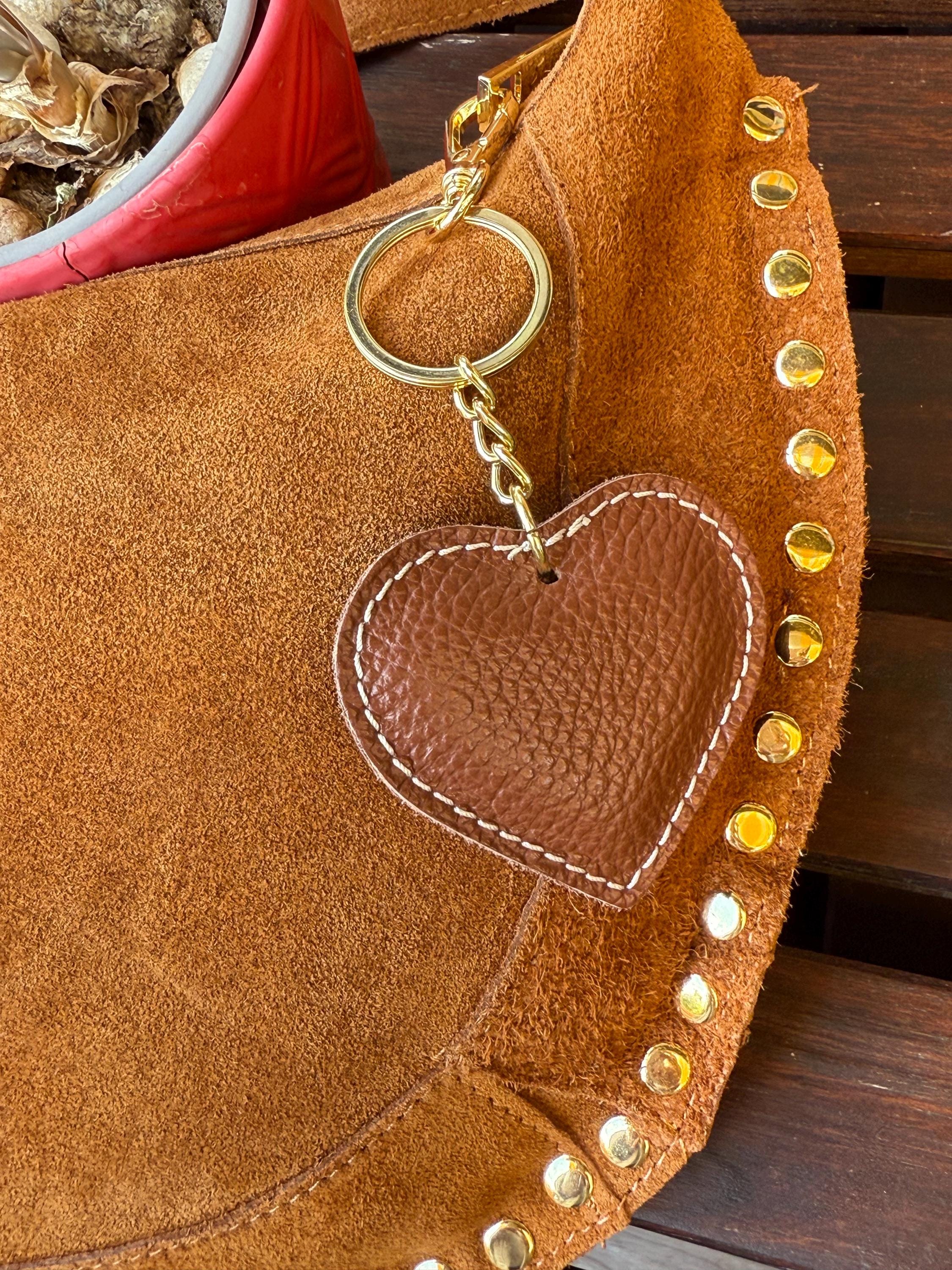 Bolso de hombro en forma de media luna de ante color camello con tachuelas doradas