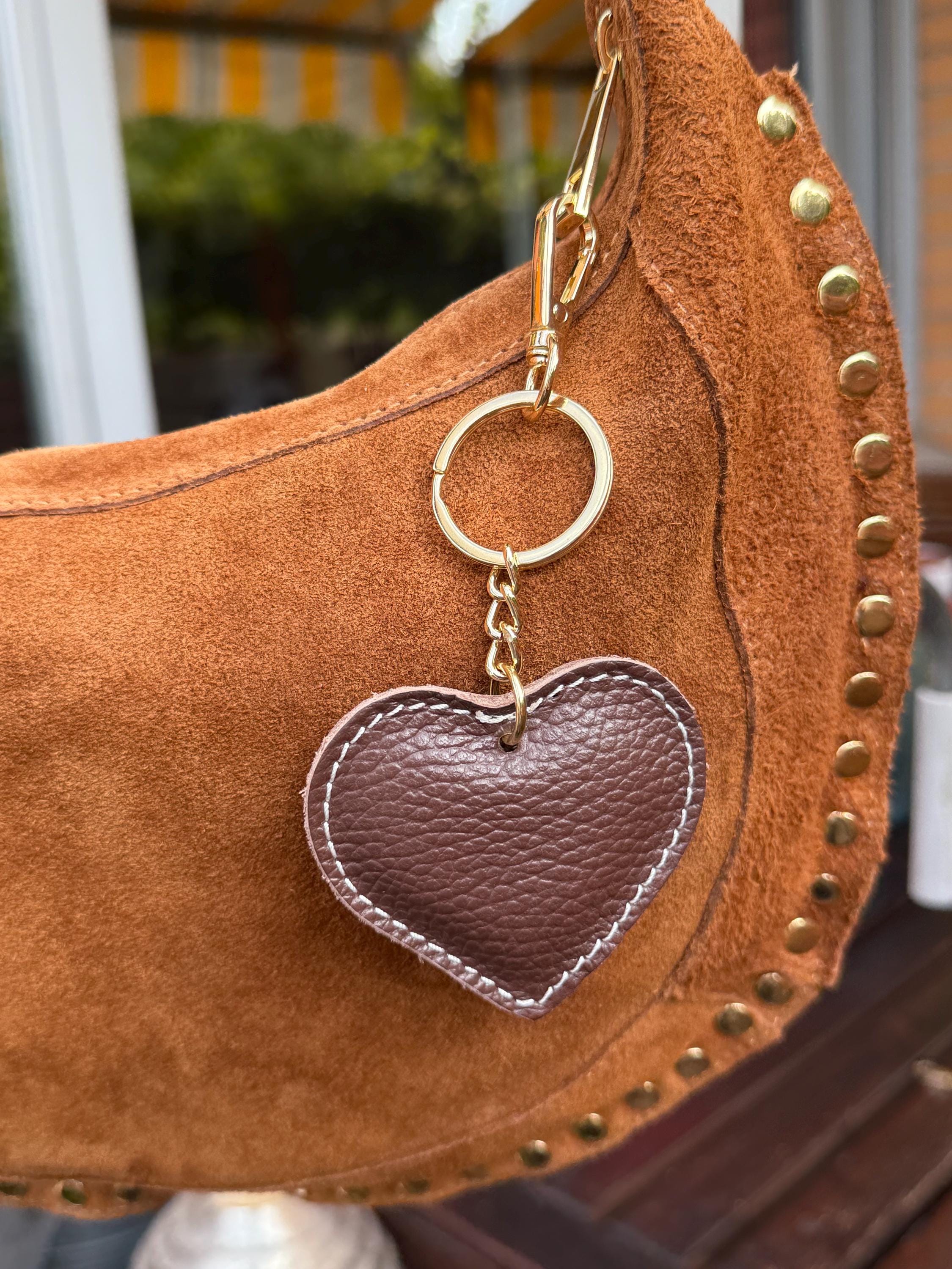 Bolso de hombro en forma de media luna de ante color camello con tachuelas doradas