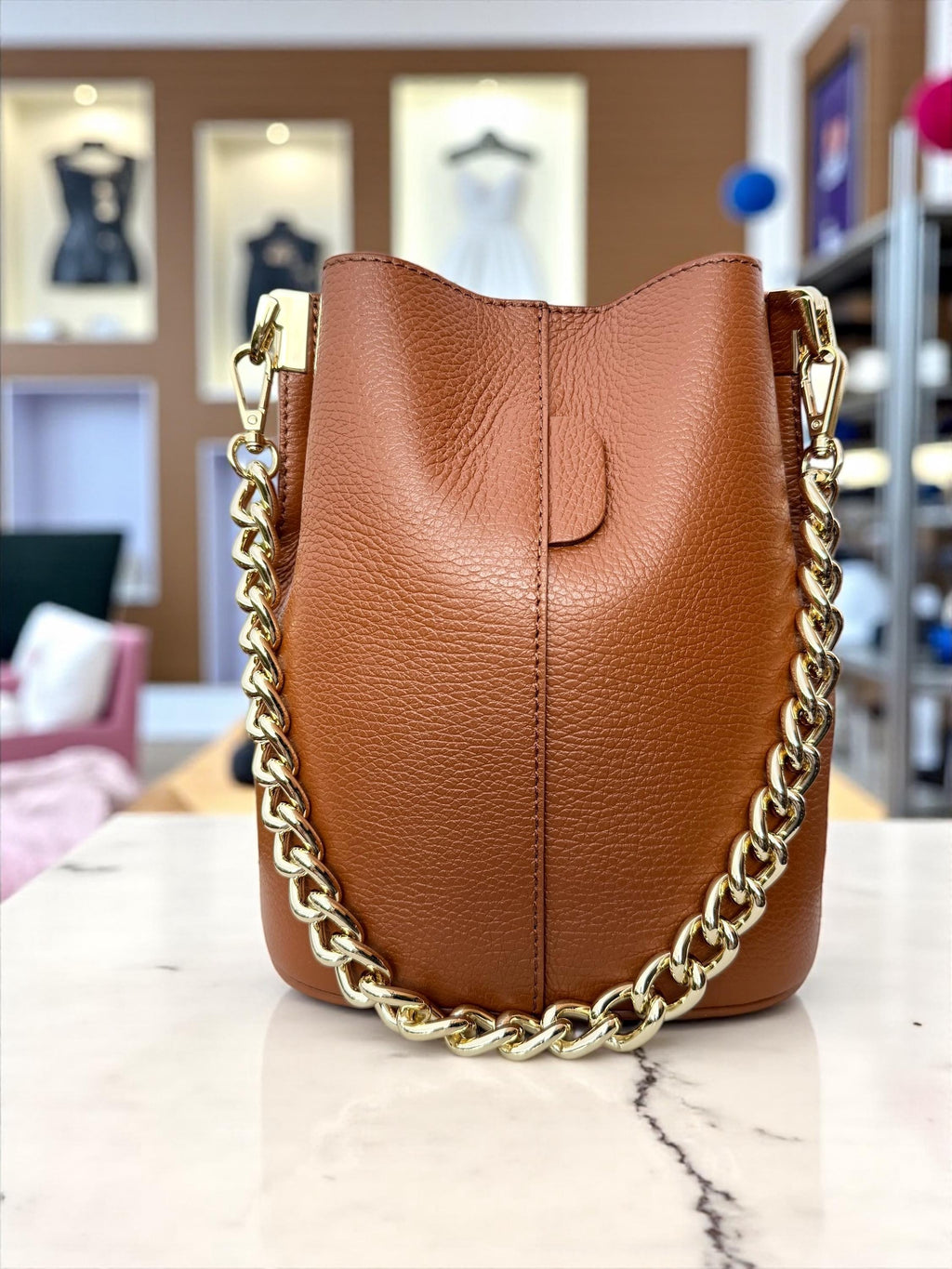 Bolso tipo cubo de piel auténtica color marrón camel con cadena dorada