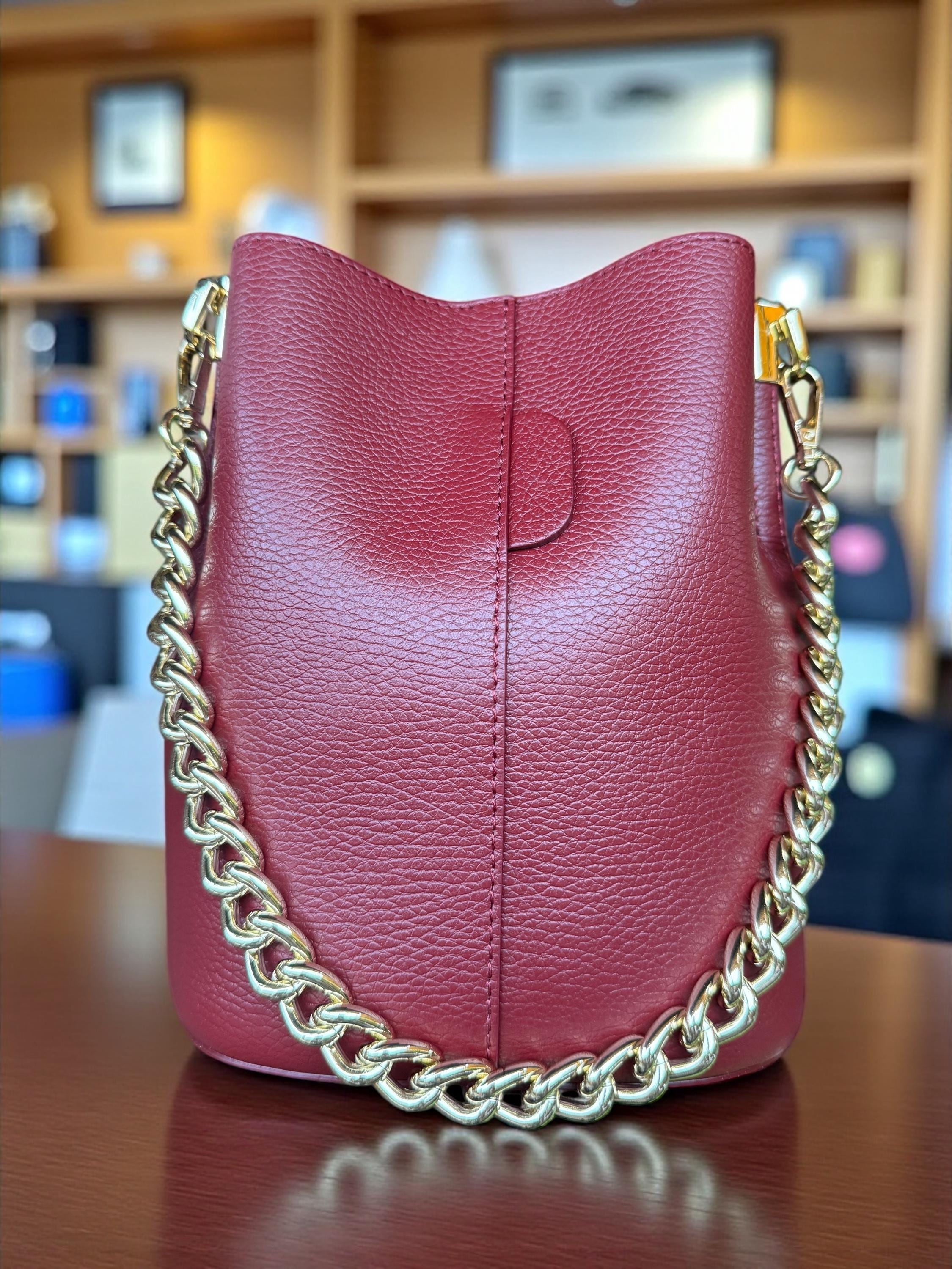 Bolso tipo cubo de piel auténtica color marrón camel con cadena dorada