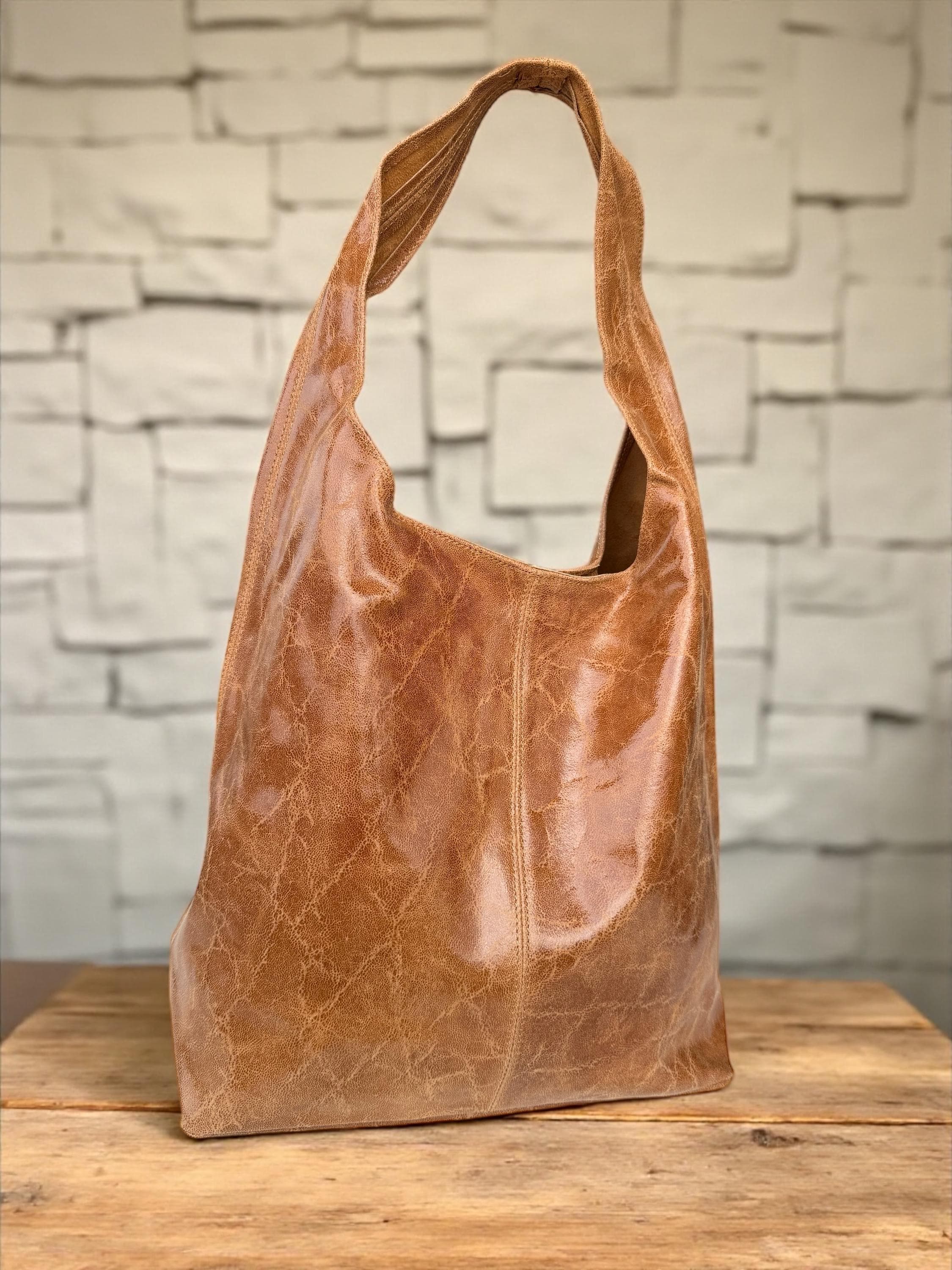 Bolso hobo boho de piel auténtica en tonos camel, marrón y azul.