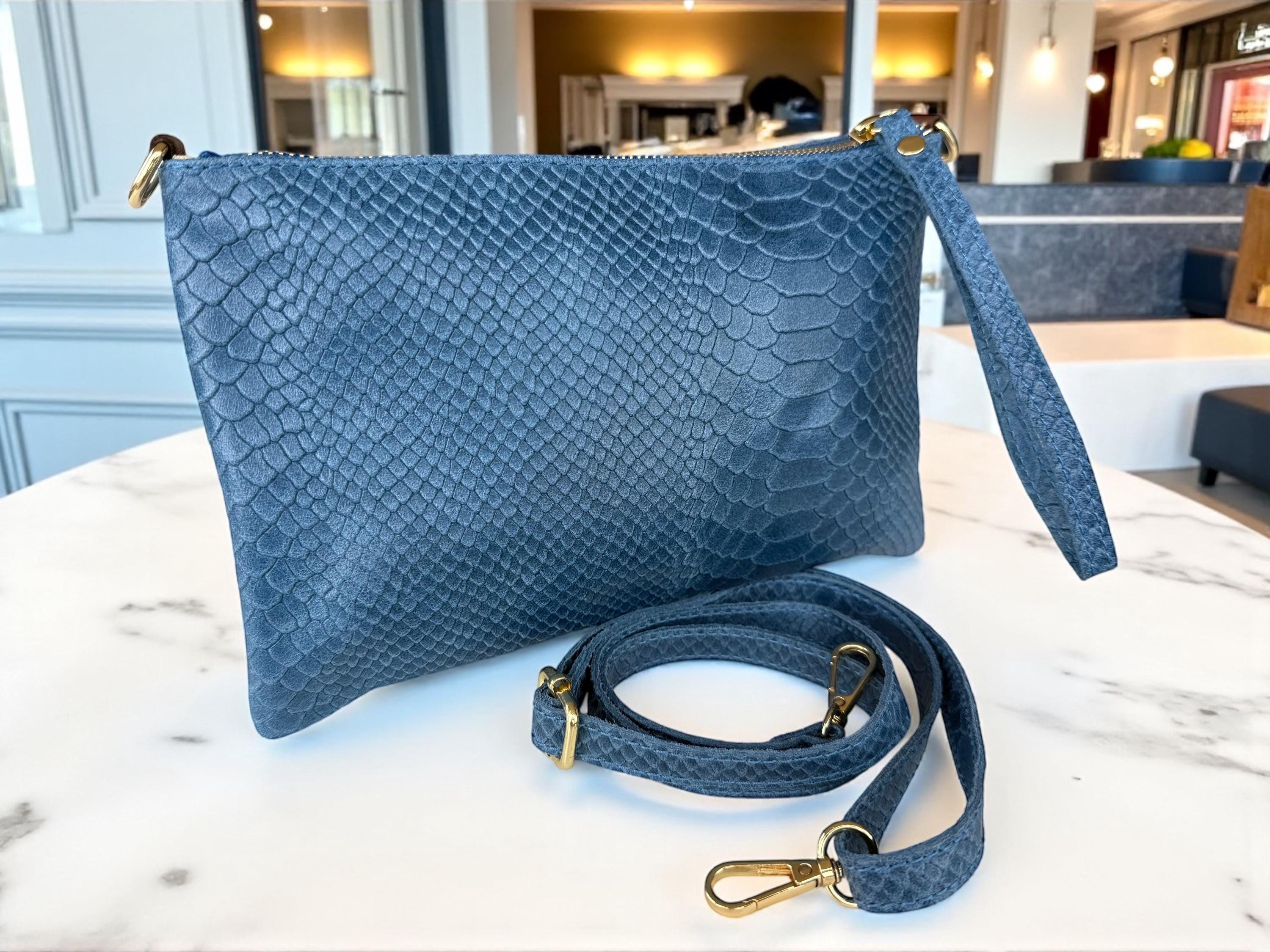 Bolso de mano azul con ribete de tachuelas y cuero repujado