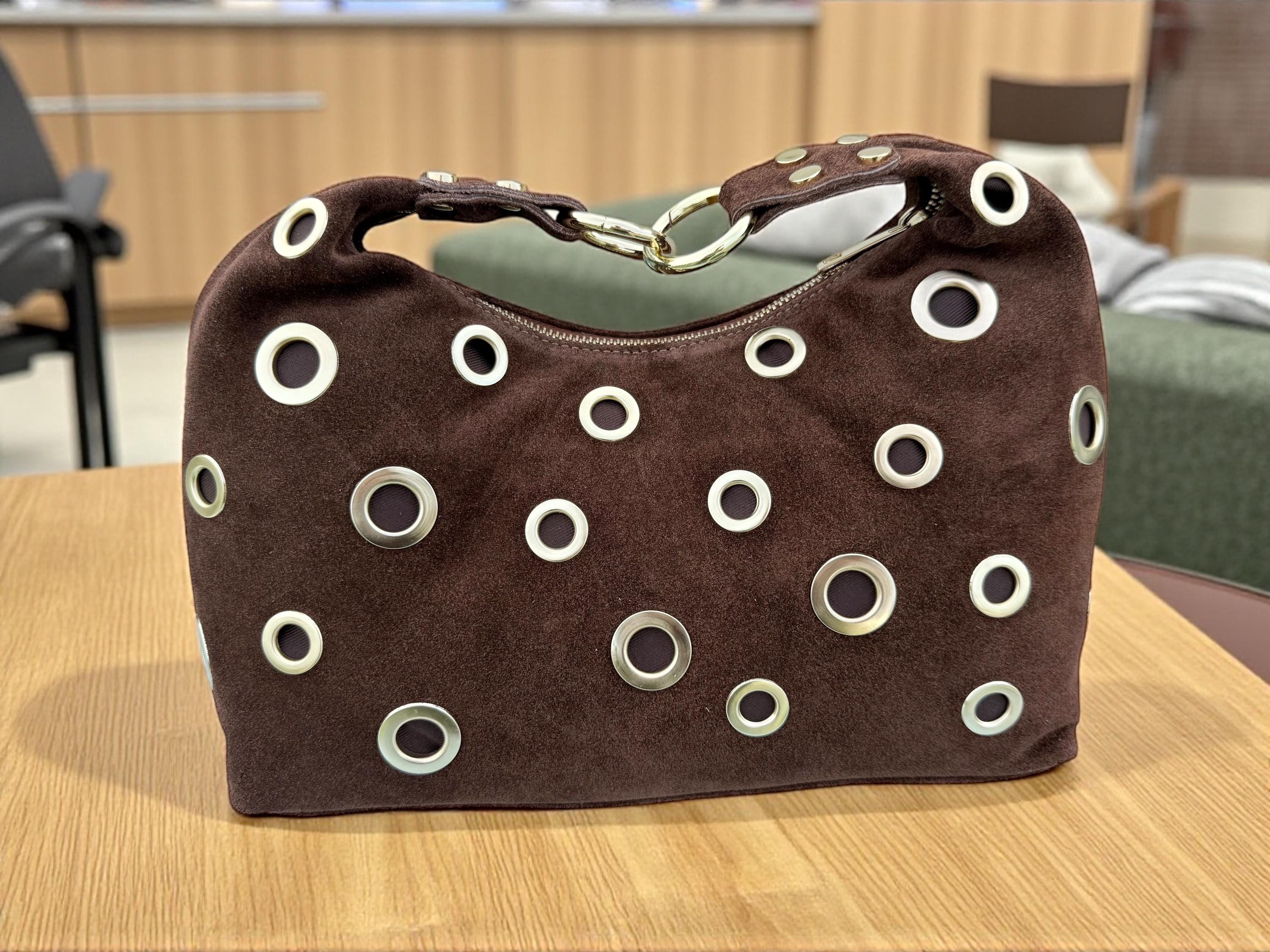 Bolso de hombro marrón de ante con ojales dorados