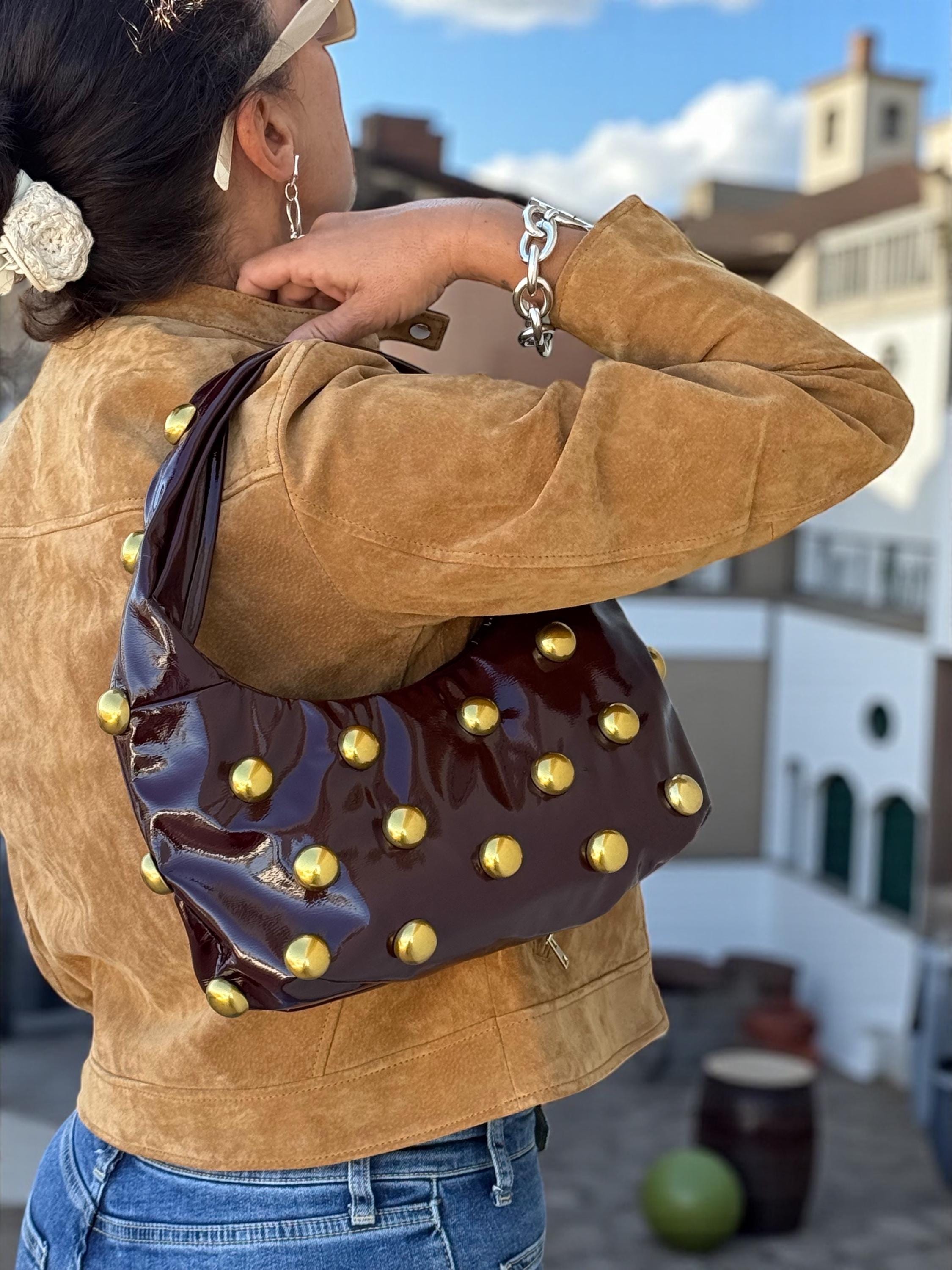 Bolso hobo de charol suave color burdeos brillante con tachuelas doradas antiguas