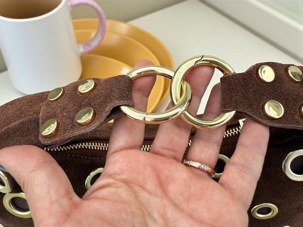 Bolso de hombro marrón de ante con ojales dorados